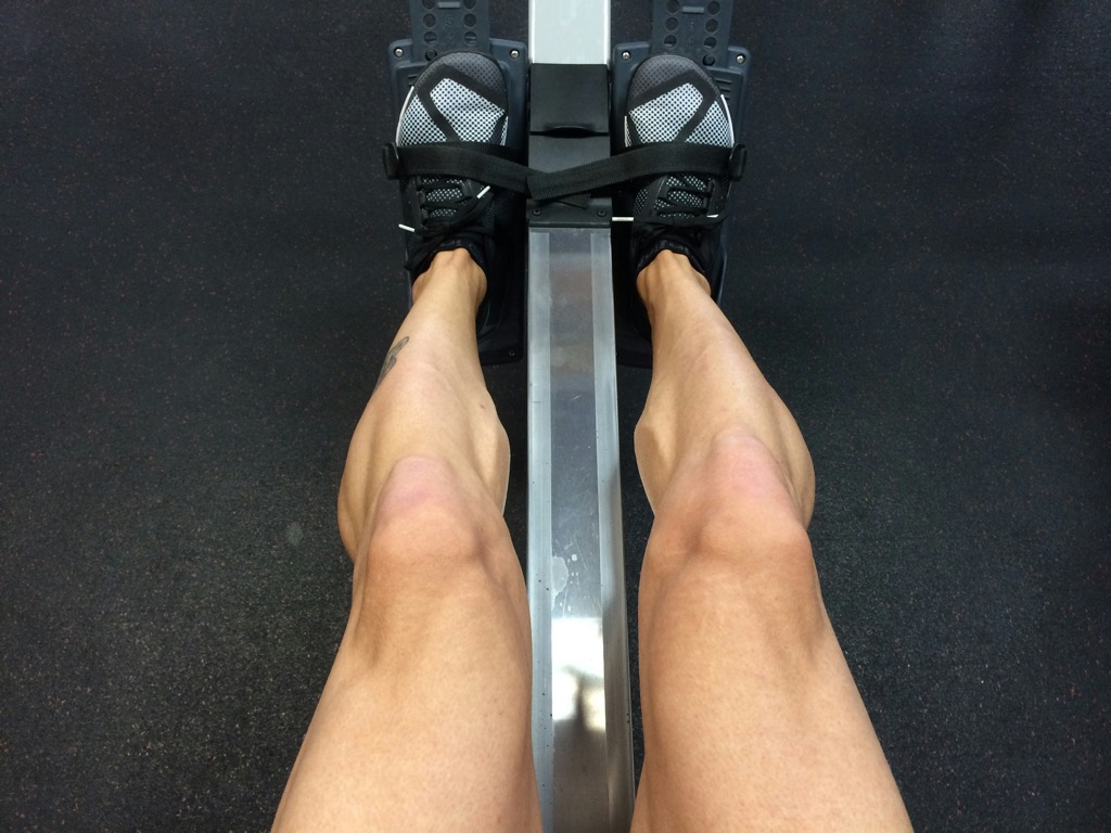 Looking down at your own legs on the erg, feet strapped into the footplate