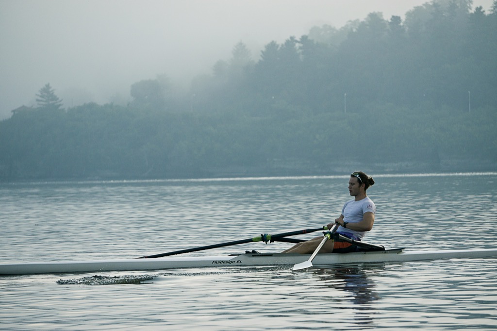 A sculler in the mist on a still lake